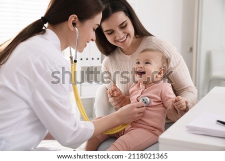 Mother with her cute baby visiting pediatrician in clinic Royalty-Free Stock Photo #2118021365