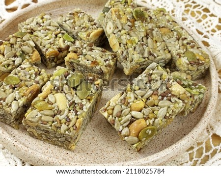 Dessert with honey, flax, pumpkin seeds and nuts. Kozinaki from pumpkin and sunflower seeds. Sweets made from nuts and seeds. Oriental sweets close-up.  Royalty-Free Stock Photo #2118025784
