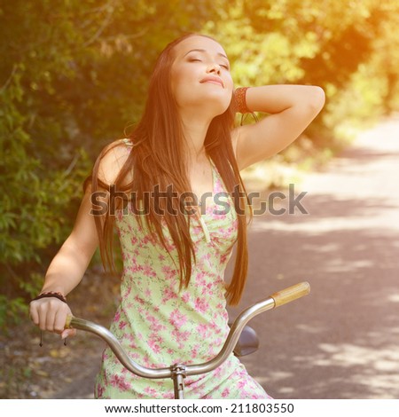 Happy smiling young beautiful woman with retro bicycle, summer outdoor, image toned
