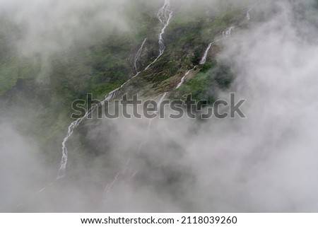 A watefall in austrian Stubai Alps in clouds.