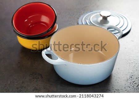 Dutch oven and enameled pewter on a black surface. Royalty-Free Stock Photo #2118043274