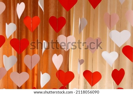Defocus banner. Valentines Day background with paper hearts. The red and white heart shapes for 14 February. Love symbol. Cupid's bow. Red backdrop. Pattern. Out of focus.
