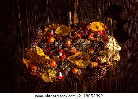 autumn theme. Halloween. autumn leaves, acorns and mushrooms are laid out in the shape of a pumpkin. bat shadow
