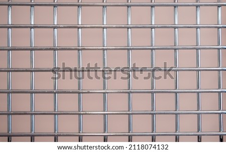 Metal chrome grate with a square mesh on a pink background. Royalty-Free Stock Photo #2118074132