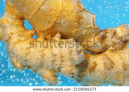 Ginger root in water close up macro. Healthy food concept.