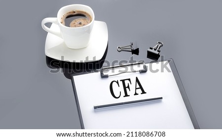 CFA text on the paper sheet with coffee on the black background