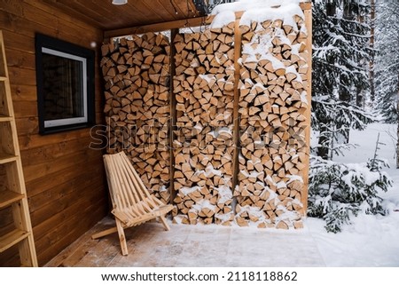 Garden chaise longue made of wood. Garden chair for outdoor seating, Logs. Chopped birch firewood in a log. Stacked firewood in the backyard. High quality photo