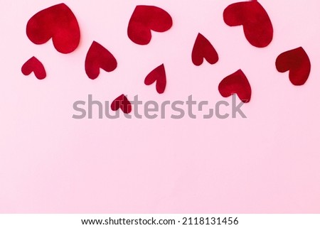Happy Valentine's Day! Stylish valentine hearts flat lay on pink background with space for text. Valentines day card template. Cute red velvet hearts cut outs  border on pink paper. Love concept