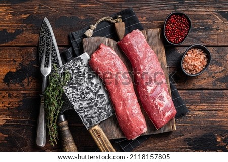 Raw lamb tenderloin fillet, Mutton fresh meat on butcher wooden board. Wooden background. Top view Royalty-Free Stock Photo #2118157805
