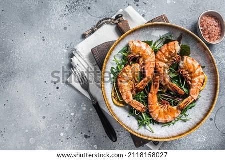 Salad with grilled Giant shrimps prawns in plate. Gray background. Top view. Free copy space