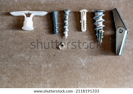 assortment of different drywall anchors used for hanging objects on walls