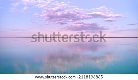 Stunning pink-purple sunrise on the Kiev Sea. Seascape with azure water and purple clouds in reflection. Tourism and recreation. Royalty-Free Stock Photo #2118196865