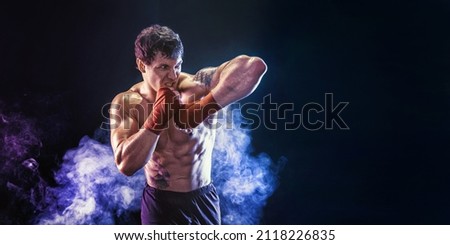 Kickboxer delivering an elbow hit isolated on smoke background. The concept of sports, mixed martial arts. Mixed media. Royalty-Free Stock Photo #2118226835