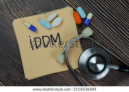 IDDM - Insulin-Dependent Diabetes Mellitus write on sticky notes isolated on Wooden Table. Medical concept