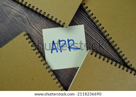 APR - Annual Precentage Rate write on sticky notes isolated on Wooden Table.