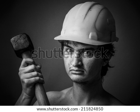 Worker in a helmet and with a sledgehammer