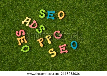Colorful alphabet or letters for seo website concept on green grass background. Our business.