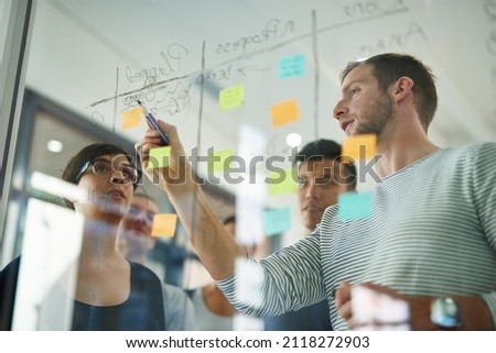 Planning is the first step. Cropped shot of a group of young designers planning on a glass board. Royalty-Free Stock Photo #2118272903