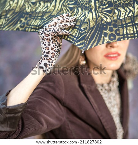 Autumn woman with umbrella over dark grey background. focus on hand and umbrella
