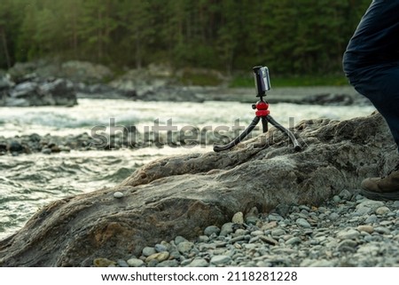 a man sets up a tripod for photography of landscape, nature