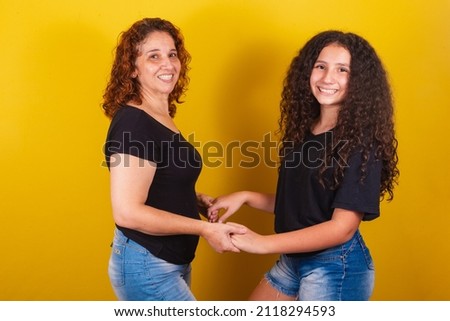 Grandmother and niece, Brazilian, Latin American, curls, afro hair, curly, smiling, hands on hips, family photo, beautiful. Mother's Day, Fraternity, Love.