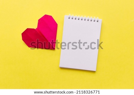 empty notebook with red heart on yellow background with space for your text. Valentine Day ,holiday, health, plan Concept