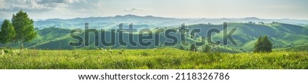 Panoramic view of a summer evening in the mountains, green meadows, mountain slopes and hills Royalty-Free Stock Photo #2118326786