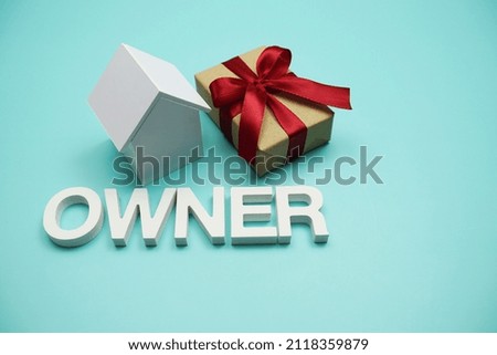 Owner alphabet letters with gift box on blue background