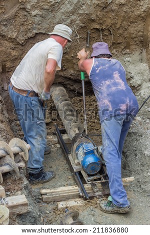 Drilling under street for sewer pipes. Drill under the road and installing pipes. selective focus and motion blur.