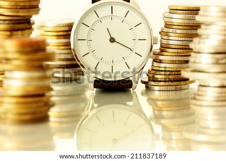  clock and stacks of coins : time - money Royalty-Free Stock Photo #211837189