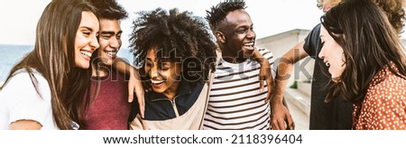 Cheerful young people walking outside talking and having fun - Mixed race friends hanging down the street - Group of teenagers having party celebrating laughing out loud - Youth lifestyle concept