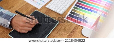 Graphic designer works on computer and selects color schemes. Photo processing concept