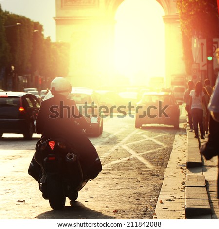 man on bike rides in Paris on road in morning at sunrise