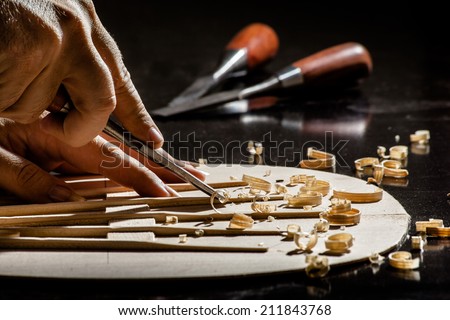 Luthier making top of guitar Royalty-Free Stock Photo #211843768