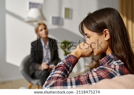 Pensive depressed woman at psychologist counseling session Royalty-Free Stock Photo #2118475274