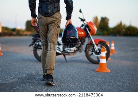 Male person holds helmet, motorcycle school Royalty-Free Stock Photo #2118475304