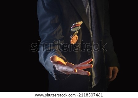 A man in a suit tosses poker chips. Poker game. Passion and passion. Poker chips in the air. A dark room. Royalty-Free Stock Photo #2118507461