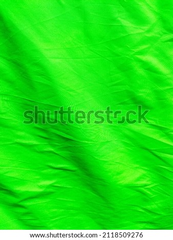 Vast view of green screen background. Used as negative space, backdrop, chroma key wallpaper, studio photo photography. Rimpled textiles cloth material. Chroma key objects