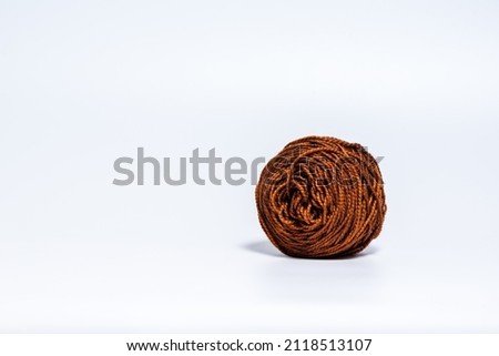 Medium size e brown ball of yarn on white background