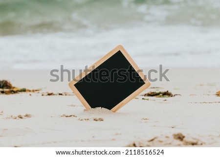 Black Chalkboard Sticking Out Of A White Sandy Beach