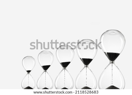 Hourglasses of various sizes on white background. Black Sand in hourglasses. Time is money. 