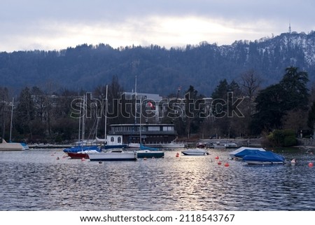 Beautiful scenic landscape with Lake Zurich in the foreground and local mountain Uetliberg in the background on a cloudy winter day. Photo taken February 3rd, 2022, Zurich, Switzerland.