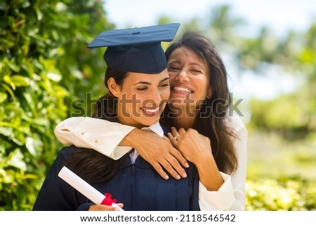 Happy mother celebrating her daughters graduation.  Royalty-Free Stock Photo #2118546542