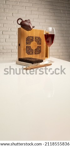 a tea table with tea and a wine glass in which Sheng Pu'er tea is poured to demonstrate the color
