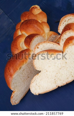 baked product : cuted golden challah on blue wooden table