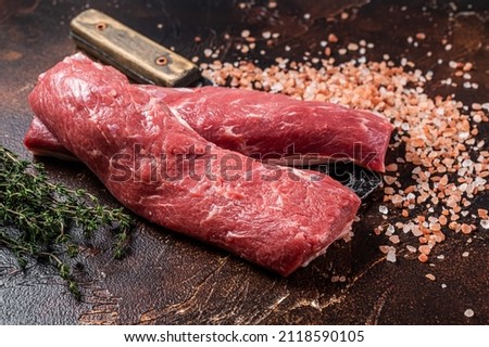 Uncooked lamb loin fillet, Mutton raw meat on butcher cleaver. Dark background. Top view Royalty-Free Stock Photo #2118590105