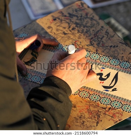 Arabic calligraphy manuscript. Writer writing by hand in the street