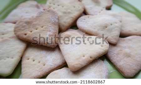 A full green plate of sweet homemade heart-shaped cookies for the holiday              