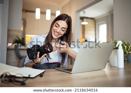 Woman working on laptop in home. Freelance photographer edit photos on computer. Professional photography business. Girl workspace with computer and photo camera. Creative artist lifestyle Royalty-Free Stock Photo #2118634016
