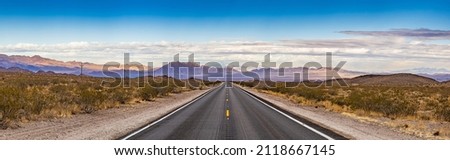 Panoramic image of a lonely, seemingly endless road in the desert of Southern California Royalty-Free Stock Photo #2118667145